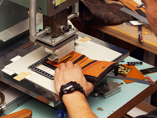 革財布に名前を刻印している職人の手元のアップ